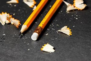 Two pencils with shavings on black background. Horizontal image. photo