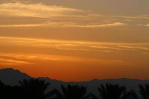 Sunrise at the Dead Sea in Israel. The sun comes out from behind the mountains in Jordan. photo