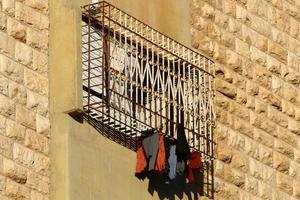 Washed linen dries on the street outside the window of the house. photo