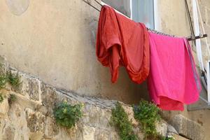 Washed linen dries on the street outside the window of the house. photo