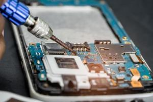 Technician repairing inside of mobile phone by soldering iron. Integrated Circuit. the concept of data, hardware, technology. photo