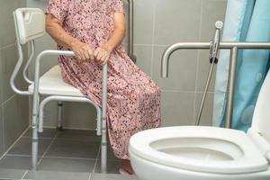 Asian senior or elderly old lady woman patient use toilet bathroom handle security in nursing hospital ward, healthy strong medical concept. photo