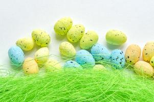 Artificial grass with colored eggs background photo