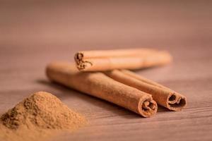 cinnamon sticks and powder on wooden table. Soft focus photo