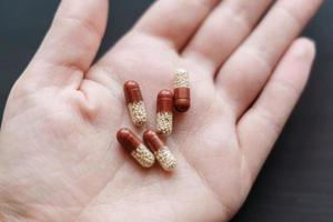 medicine transparent capsules in woman hand photo