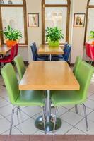 interior of the cafe - wooden tables and multicolored leather chairs photo