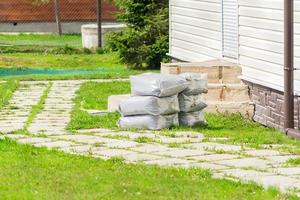 bags with soil on the lawn in front of the house photo