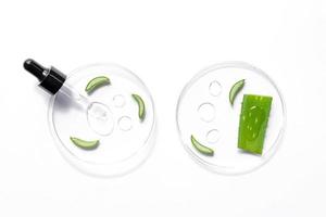 Natural cosmetic laboratory concept. Petri dishes with cosmetic gel of Aloe Vera plant, pipette dropper with serum on white background top view photo