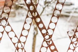 valla perforada sobre fondo de nieve. foto