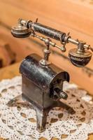 vintage retro phone on wooden table covered with openwork napkin photo