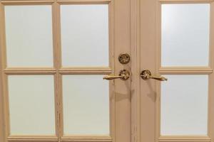 closeup of wooden door with glass and metal handles photo