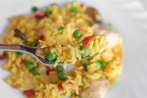 paella with chicken and seafood on white plate. photo