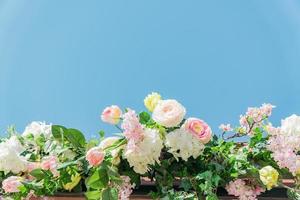 artificial flowers on blue sky background outdoors, street decorations close up photo