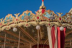 Closeup of French carousel in a holiday park. Merry-go-round with horses photo