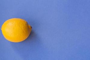top view of fresh ellow lemon on blue background photo