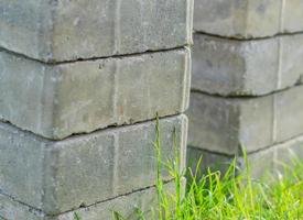 pila de ladrillos grises de pavimento sobre hierba verde foto