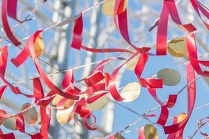 red strips of cloth hanging on a string against blue sky photo