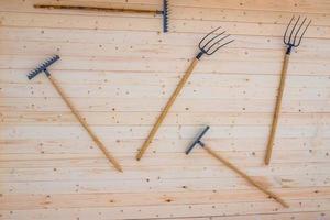 tenedores y rastrillos colgados en la pared de madera foto