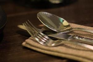 Served fork, spoon and knife on table. Soft focus photo