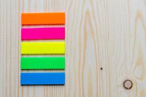 multicolored bookmark stickers on wooden background photo