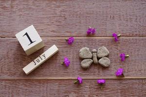 first day of July, colorful background with calendar, flowers and clay butterfly photo