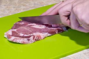 Raw pork steak on green cutting board. photo