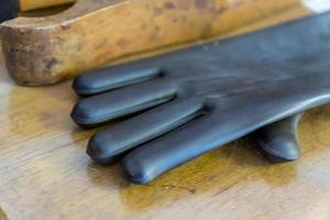 primer plano de un guante de goma negro sobre una mesa de madera foto