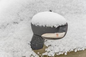 closeup of sideview mirror covered with snow photo