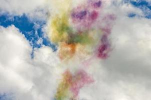 Colorful smoke in blue sky with clouds photo