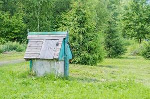 closed rustic wooden draw-well on forest background photo