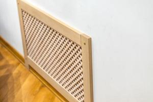 closeup of wooden cover radiator on the wall photo