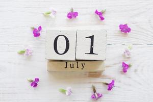 first day of July, colorful background with calendar and pink flowers photo