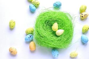 Artificial green nest with two eggs on white background photo