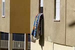 Washed linen dries on the street outside the window of the house. photo