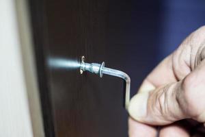 Assembling of furniture, closeup hex wrench in man hand photo