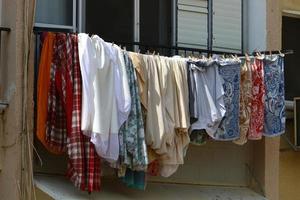 Washed linen dries on the street outside the window of the house. photo