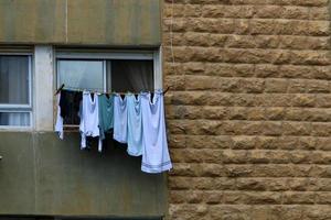 Washed linen dries on the street outside the window of the house. photo