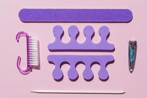 Set of pedicure tools on pink background. Still life of pedicure equipment. Knolling, top view. Mockup photo