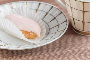 french eclairs on colorful porcelain plate on wooden table. photo