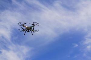 flying drone with remote control against blue sky background. photo