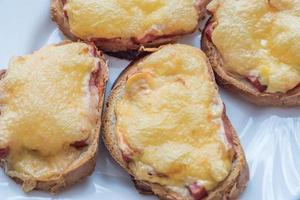 close-up of baked hot sandwiches with cheese and sausage on white plate photo