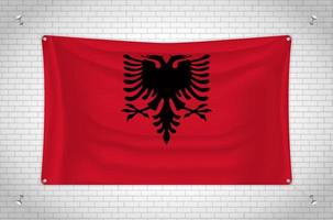 bandera de albania colgada en la pared de ladrillo. dibujo 3d bandera pegada a la pared. dibujar cuidadosamente en grupos en capas separadas para facilitar la edición. vector