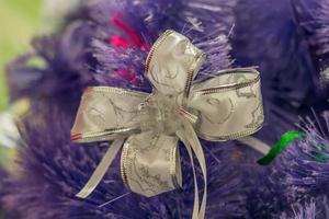 primer plano de la decoración del árbol de Navidad. lazo morado decorativo en un árbol de pieles foto