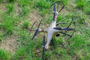 fallen drone on green grass after remote control disconnection photo
