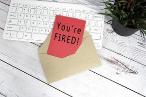 You are fired text on red note inside brown envelope. photo