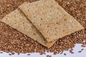 close up of flax seeds isolated and two slices of rye bread on white background photo