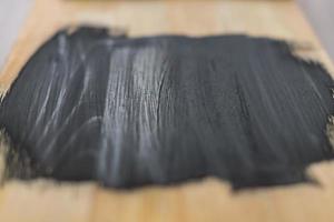 black paint on wooden background. selective focus photo