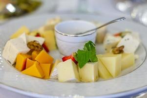 Plate of cheese with honey and fruits photo