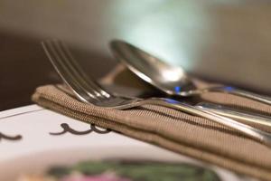 Served fork, spoon and knife on table. Soft focus photo