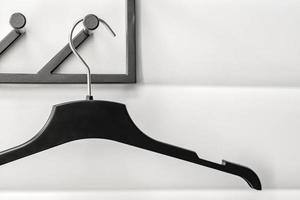 black plastic hanger on white wall background photo